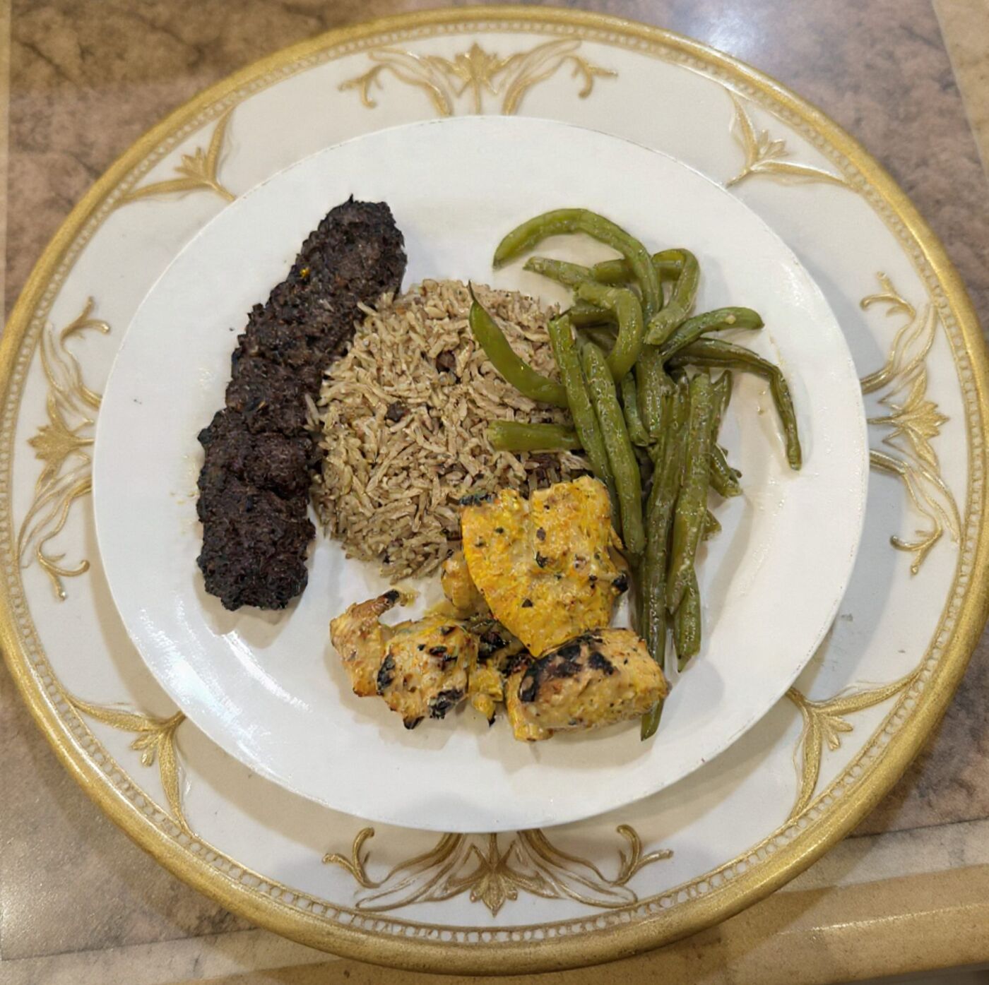 Kafta kabob and chicken tikka plated with rice and green beans